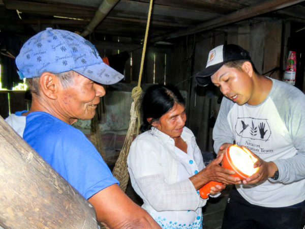 ACT team member explains use of solar lamps to community member