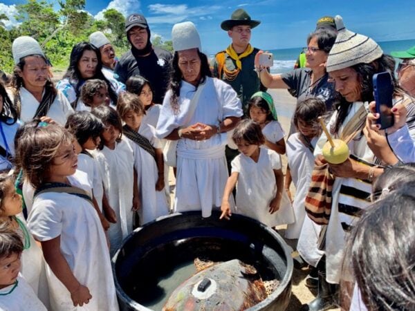 Spiritual leaders Mamo Camilo (Arhuaco people) and Mamo Salet (Kogui people) make an offering before releasing a rescued hawksbill sea turtle with a GPS transmitter in the Kutunsama community, Sierra Nevada de Santa Marta, Colombia.