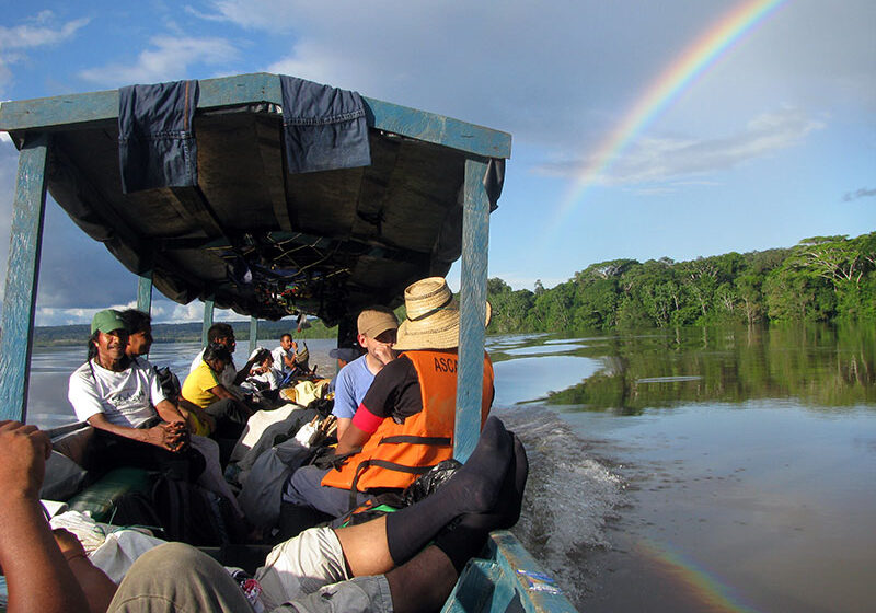 Team in a boat in the Middle Caqueta region with a beautful view of a rainbow