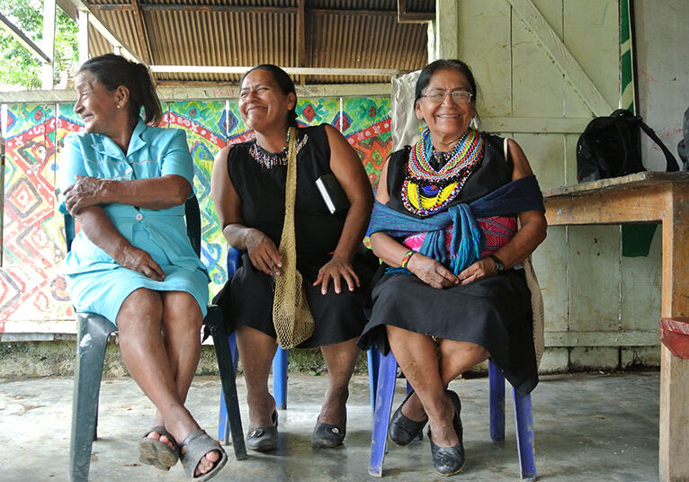 Three women sitting side-by-side in Yachaikury
