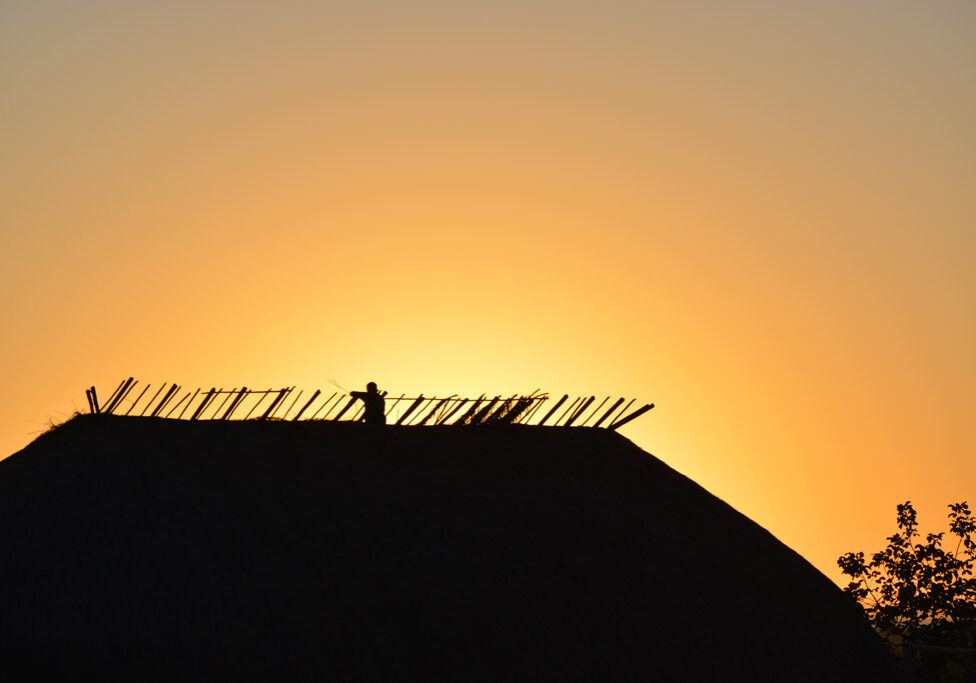 Sunset over thatched roof in Brazil
